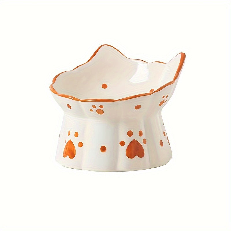 Ceramic cat-shaped bowl with orange paw prints on a white background