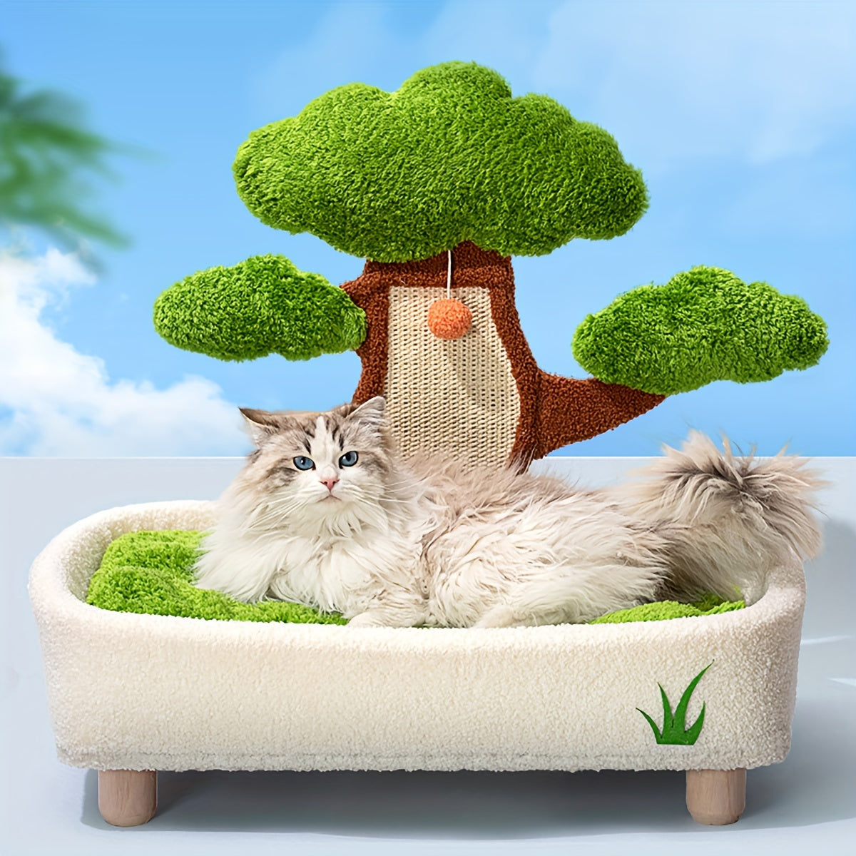 Cat lying on a tree-shaped pet bed with a green tree and orange ball in the background.