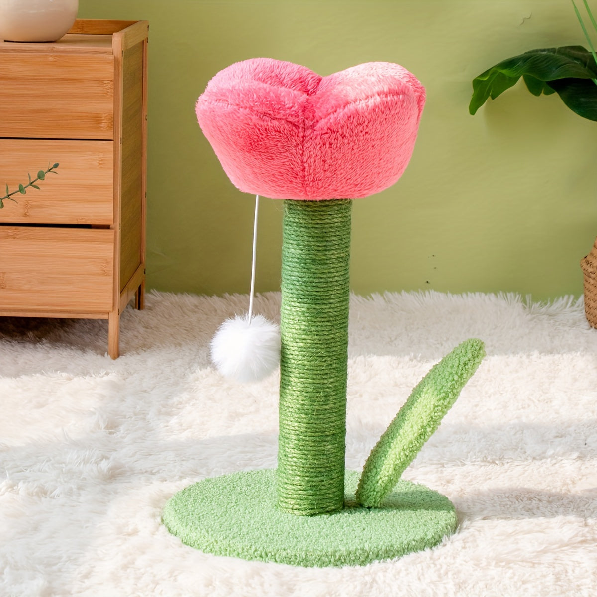 Cat toy shaped like a pink flower with green stem and base on a white carpet.
