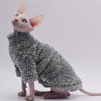 Sphynx cat wearing a textured gray sweater on a light gray background