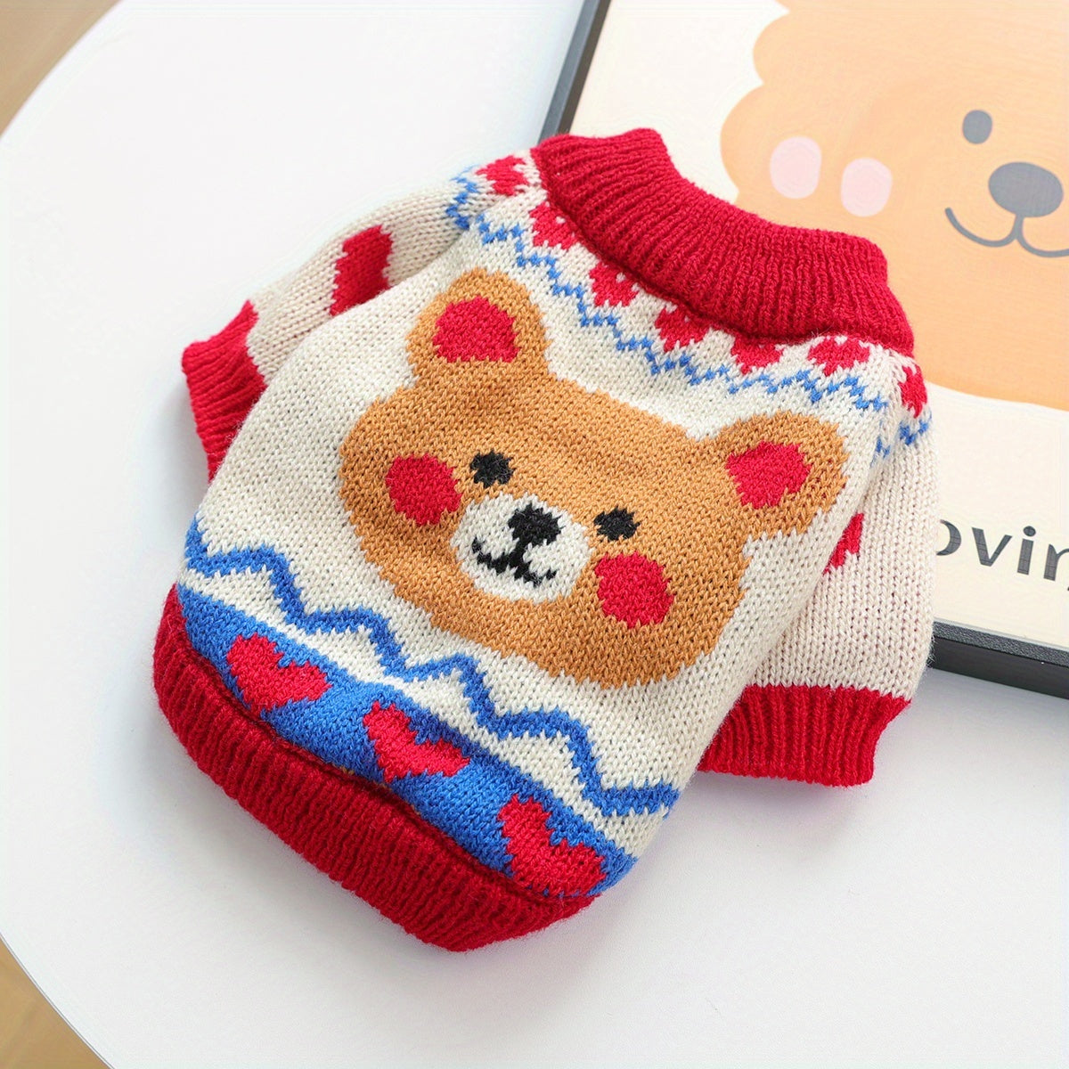 Knitted dog sweater with bear design on a white background