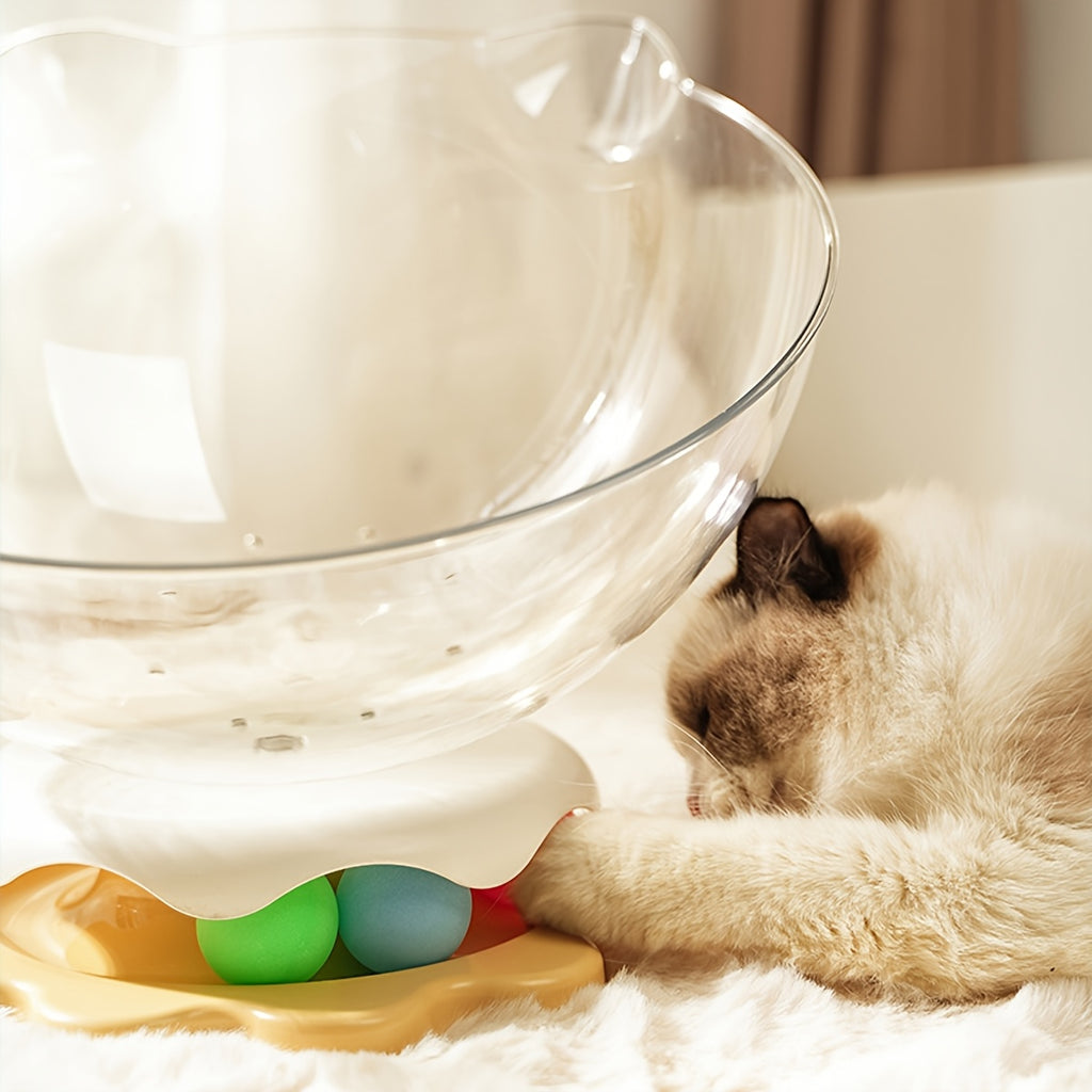 Cat interacting with a colorful pet toy on a white surface
