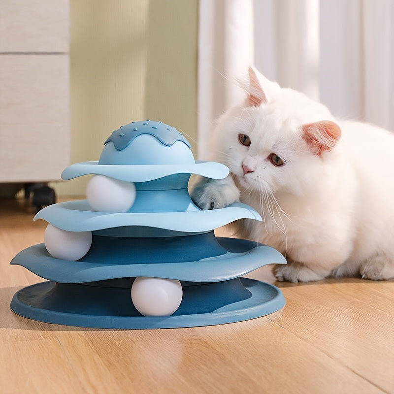 White cat playing with a blue three-tiered cat toy on a wooden floor.