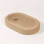 Beige woven pet bed with a ball on a white background