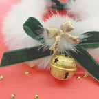 Decorative item with gold bell, green ribbon, and white fluffy element on a red background