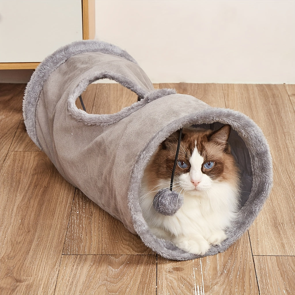 Cat playing with a plush tunnel toy on a wooden floor