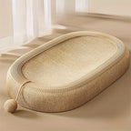 Beige woven pet bed on a beige surface with white curtains in the background