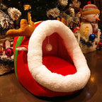 Red and white pet bed shaped like a sleigh with Christmas decorations in the background.