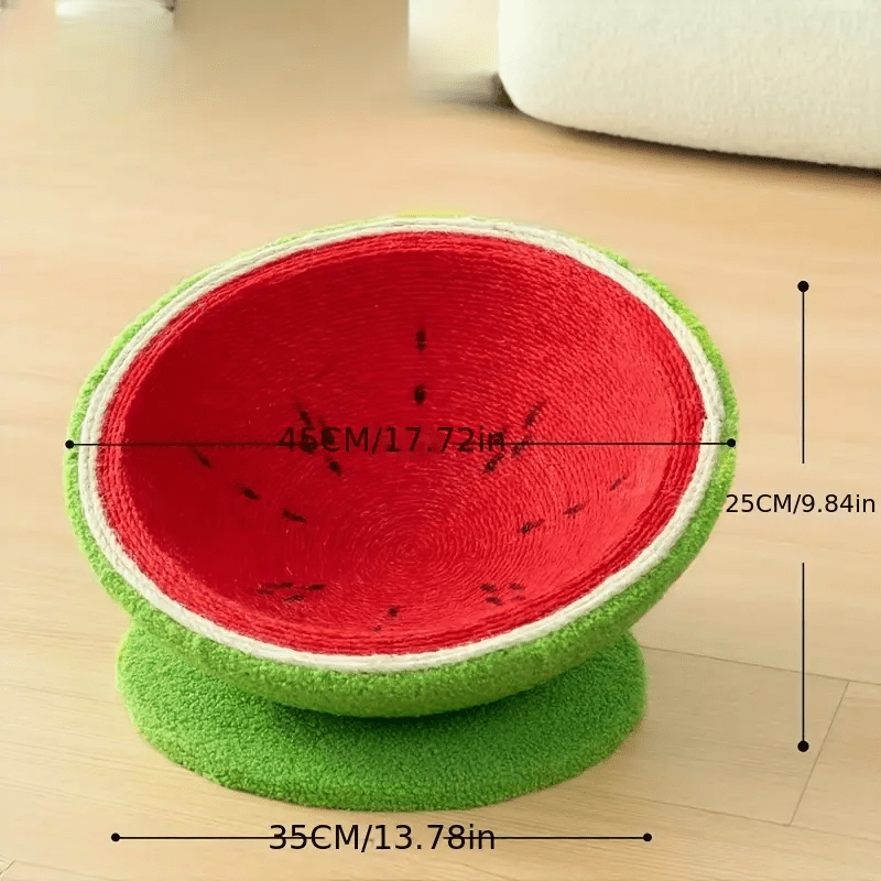Red and green pet bed shaped like a watermelon with measurements on a wooden floor.