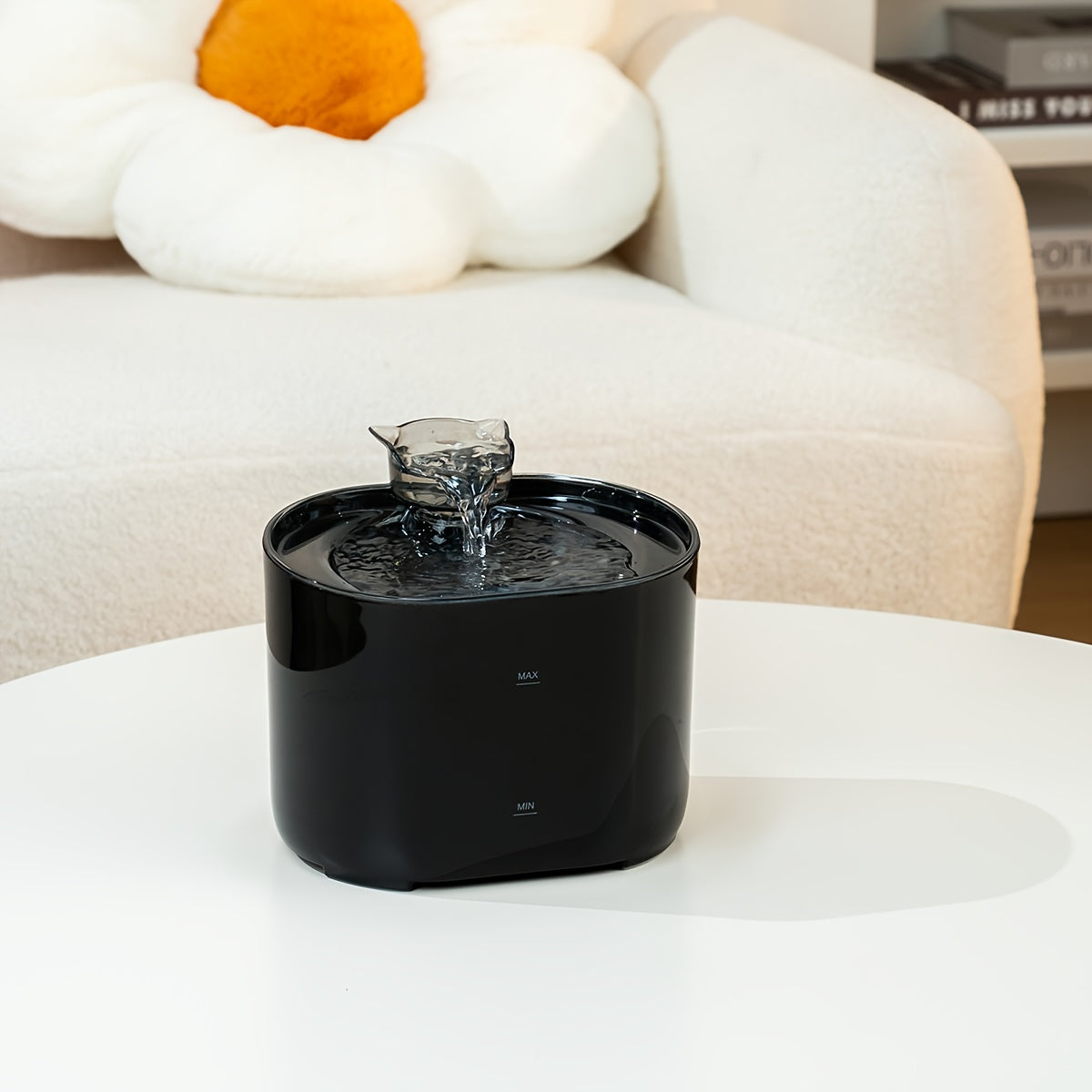 Black pet water fountain on a white surface with a blurred background