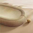 Round woven mat with a string and ball on a beige background