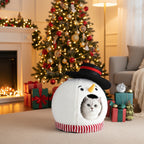 Cat inside a snowman-shaped pet bed with Christmas decorations on a living room background