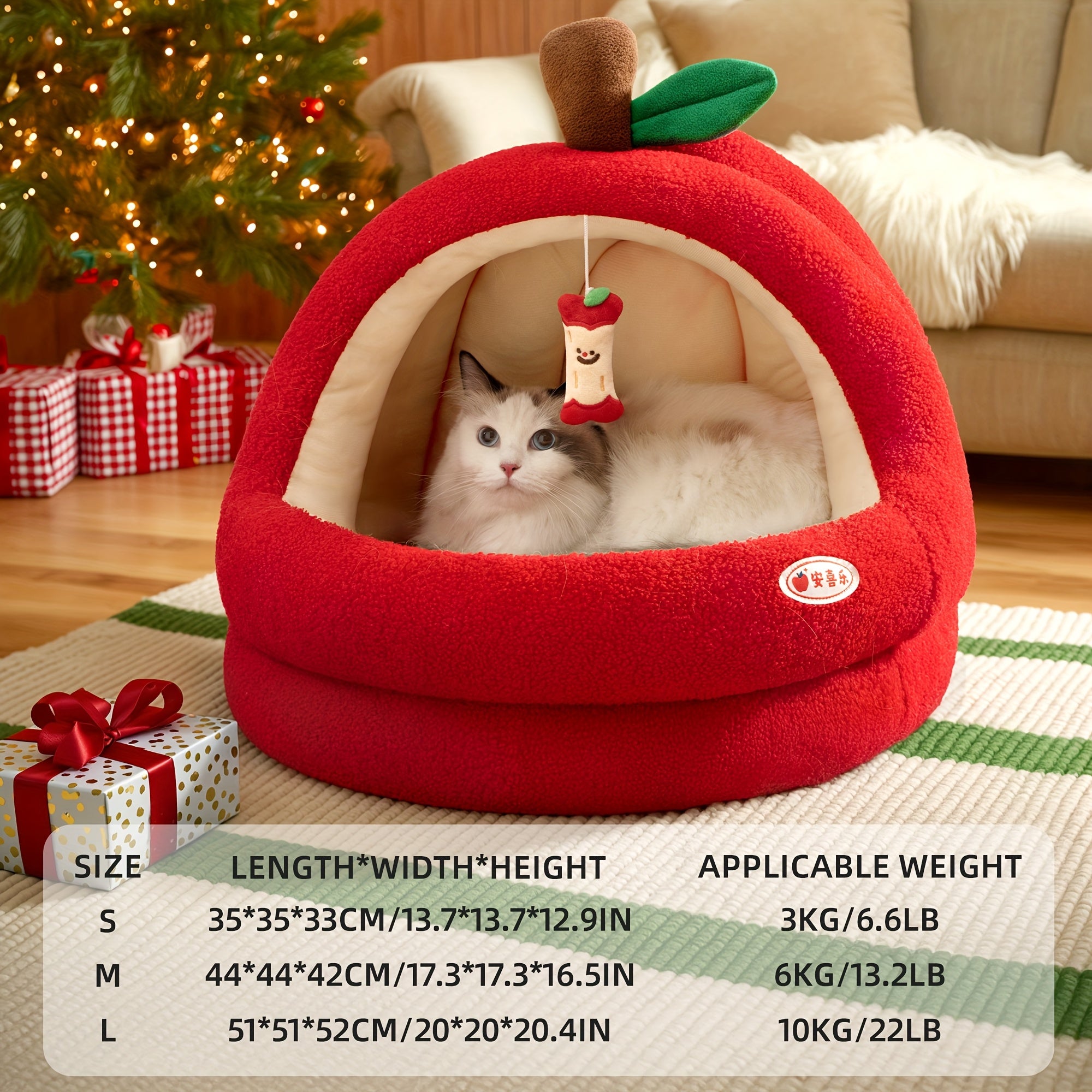 Red apple-shaped pet bed with a cat inside, surrounded by Christmas decorations.