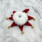 Red star-shaped decorative item with a white center and gold accents on a marble background