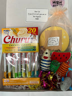 Cat toy box with various cat toys and treats on a white background