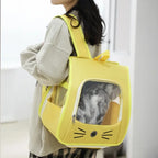 Person carrying a yellow pet carrier with a cat inside, set against a neutral background.