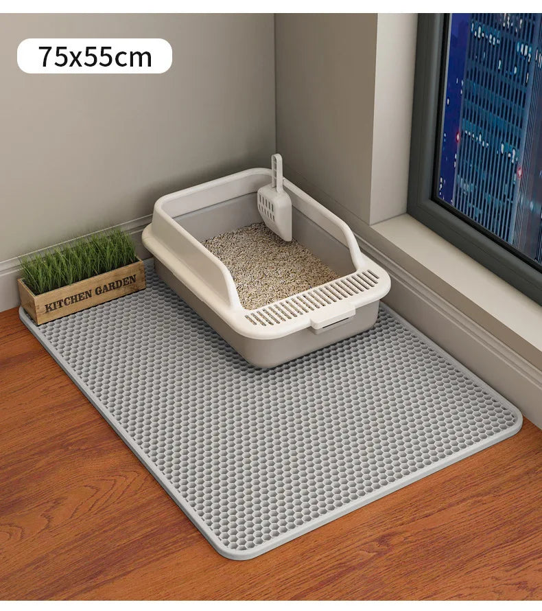 Cat litter box on a mat with dimensions 75x55cm, near a window with a cityscape view.