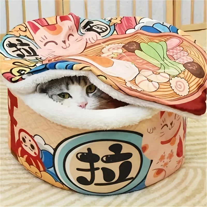 Cat peeking out from a colorful cat bed designed like a bowl of ramen.