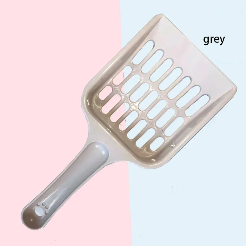 Cat litter scoop with a gray handle on a two-tone pink and blue background