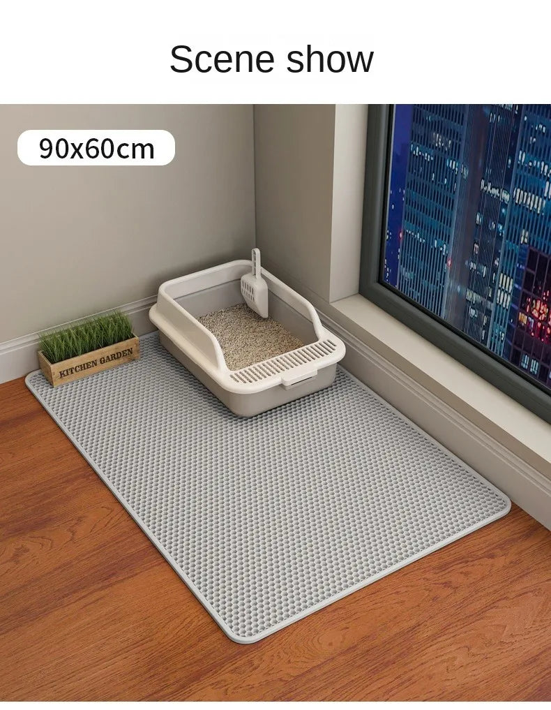 Cat litter tray with mat on a wooden floor next to a television.