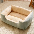 Pet bed with light blue and beige sides on a fluffy white carpet