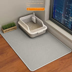 Cat litter box on a perforated mat with a cityscape in the background