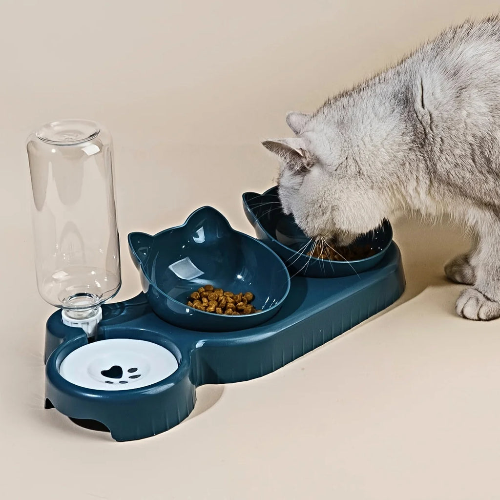 Cat using a blue pet feeder with multiple bowls on a beige surface.