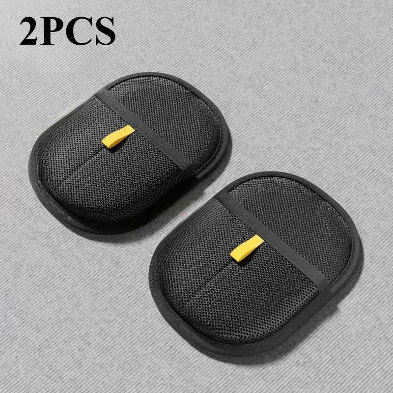 Two black mesh car seat covers with yellow straps on a gray background