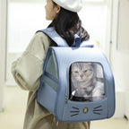 Person carrying a light blue pet carrier with a cat inside, set against a neutral background.