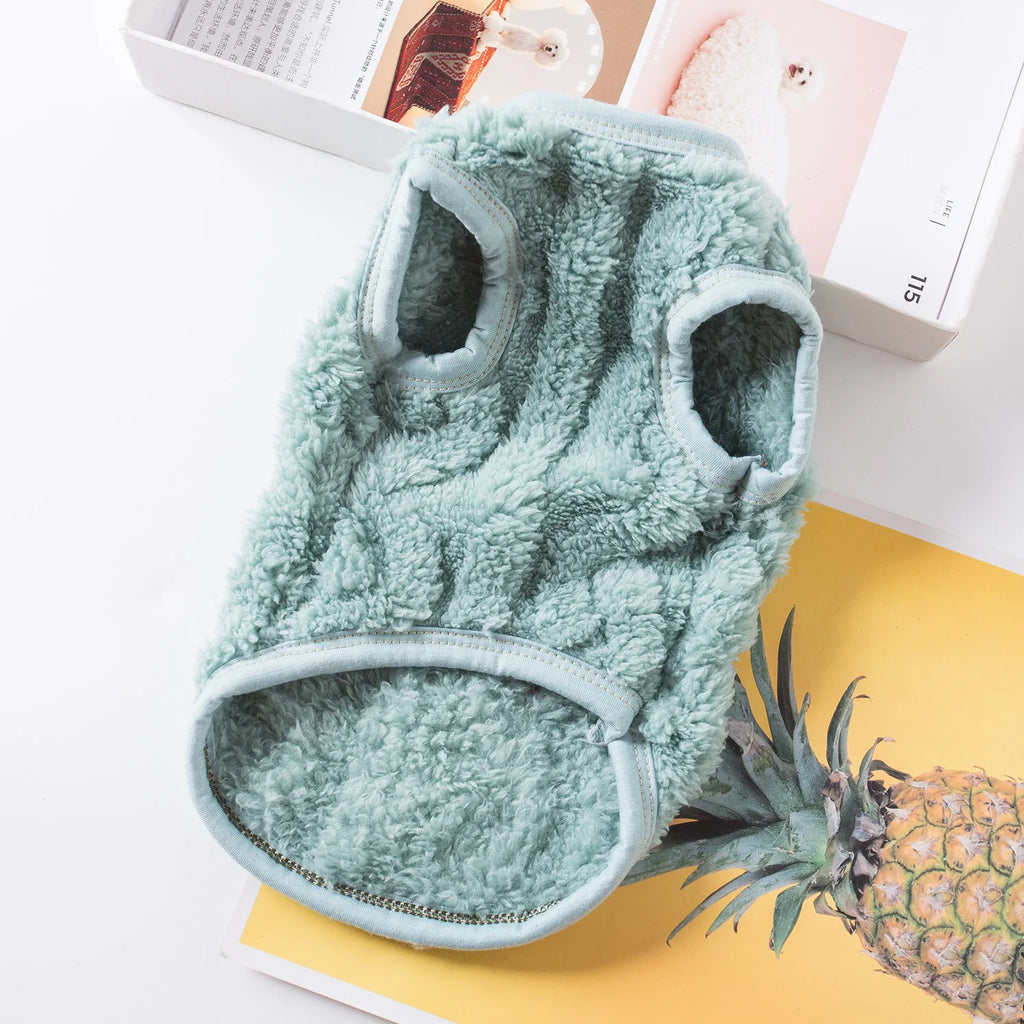 Green microfiber cleaning mitt on a white surface with a pineapple and books in the background