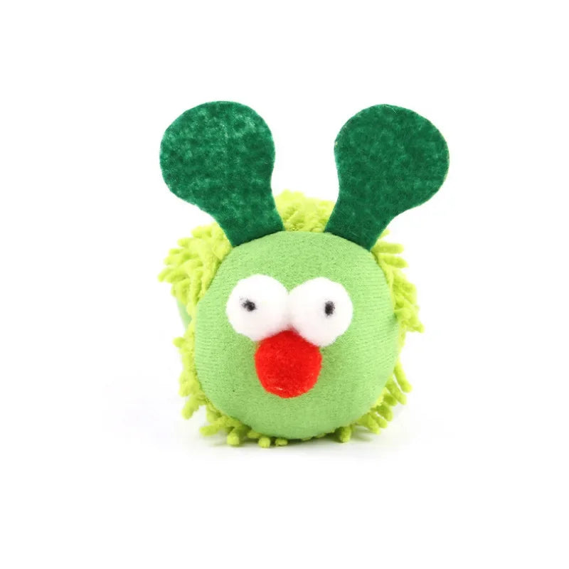 Green plush toy with googly eyes and a red nose on a white background
