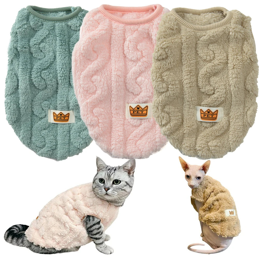 Three cable knit pet sweaters in green, pink, and beige with a cat and a small dog wearing them.