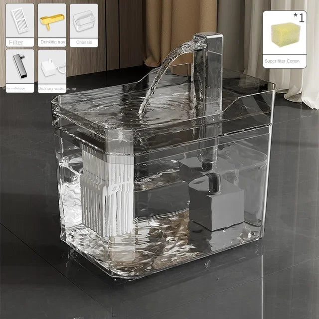 Clear acrylic fish tank with water flowing into it on a dark floor.