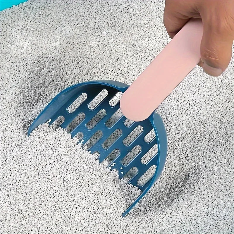 Blue scoop being used to gather cat litter on a gray surface