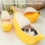 Banana-shaped pet bed with a cat inside on a light-colored floor.