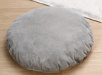 Round gray cushion on a wooden floor
