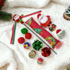 Decorative Christmas items including a red ribbon, Santa Claus figure, and colorful ornaments on a white surface.