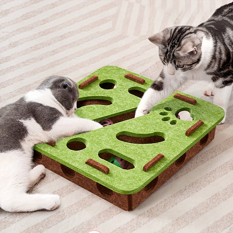 Two cats playing with a green and brown cat toy on a striped surface