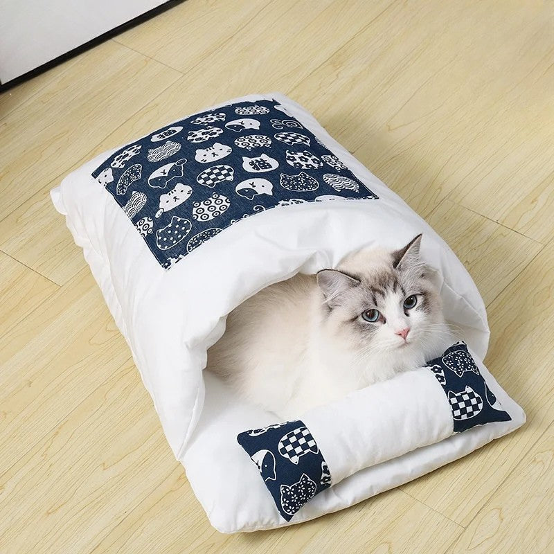 Cat lying on a white pet bed with blue patterned ends on a wooden floor