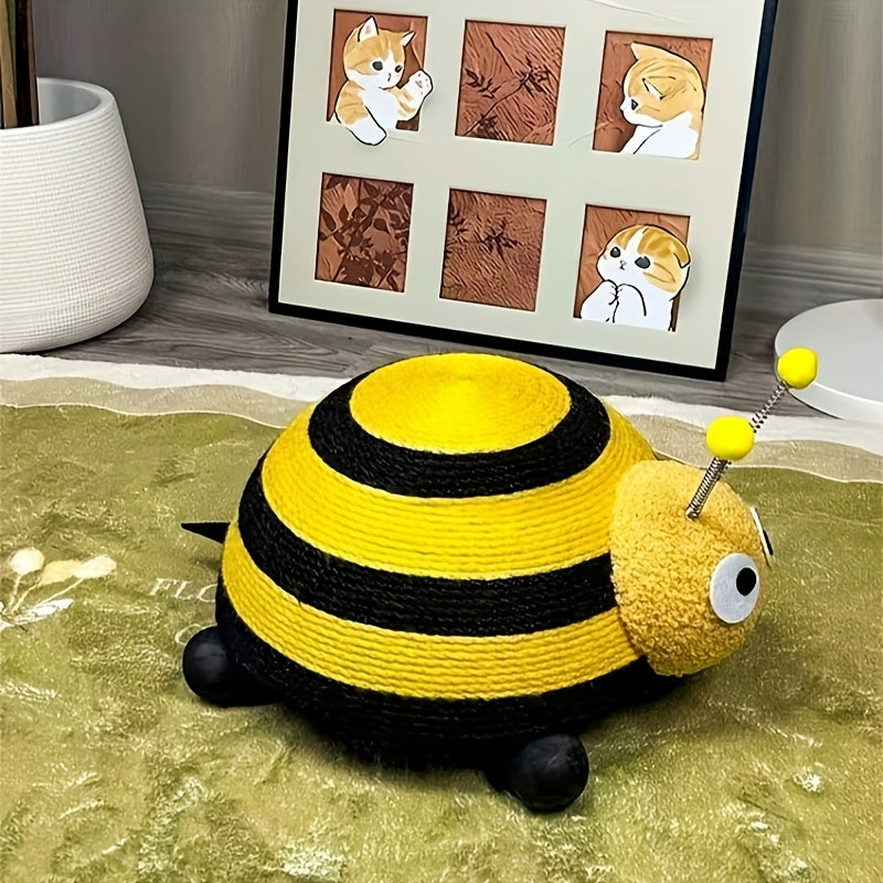 Yellow and black bee-shaped toy on a textured surface with a framed picture in the background.