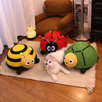 Cat playing with toy bee, ladybug, and turtle on a rug in a home setting.