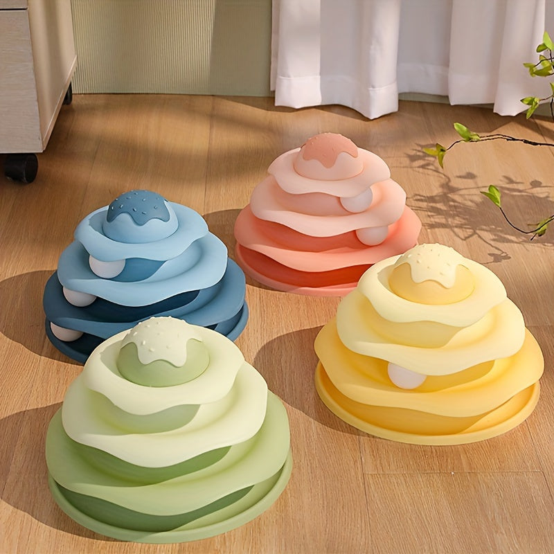 Four colorful toy rings stacked on a wooden floor with a neutral background