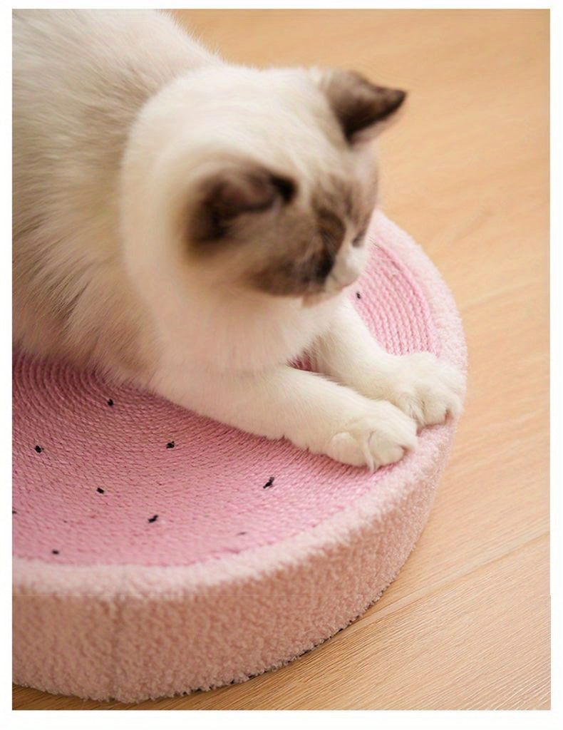 Cat on a pink cushion with black spots on a wooden floor