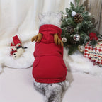 Dog wearing a red hoodie with Christmas decorations in the background