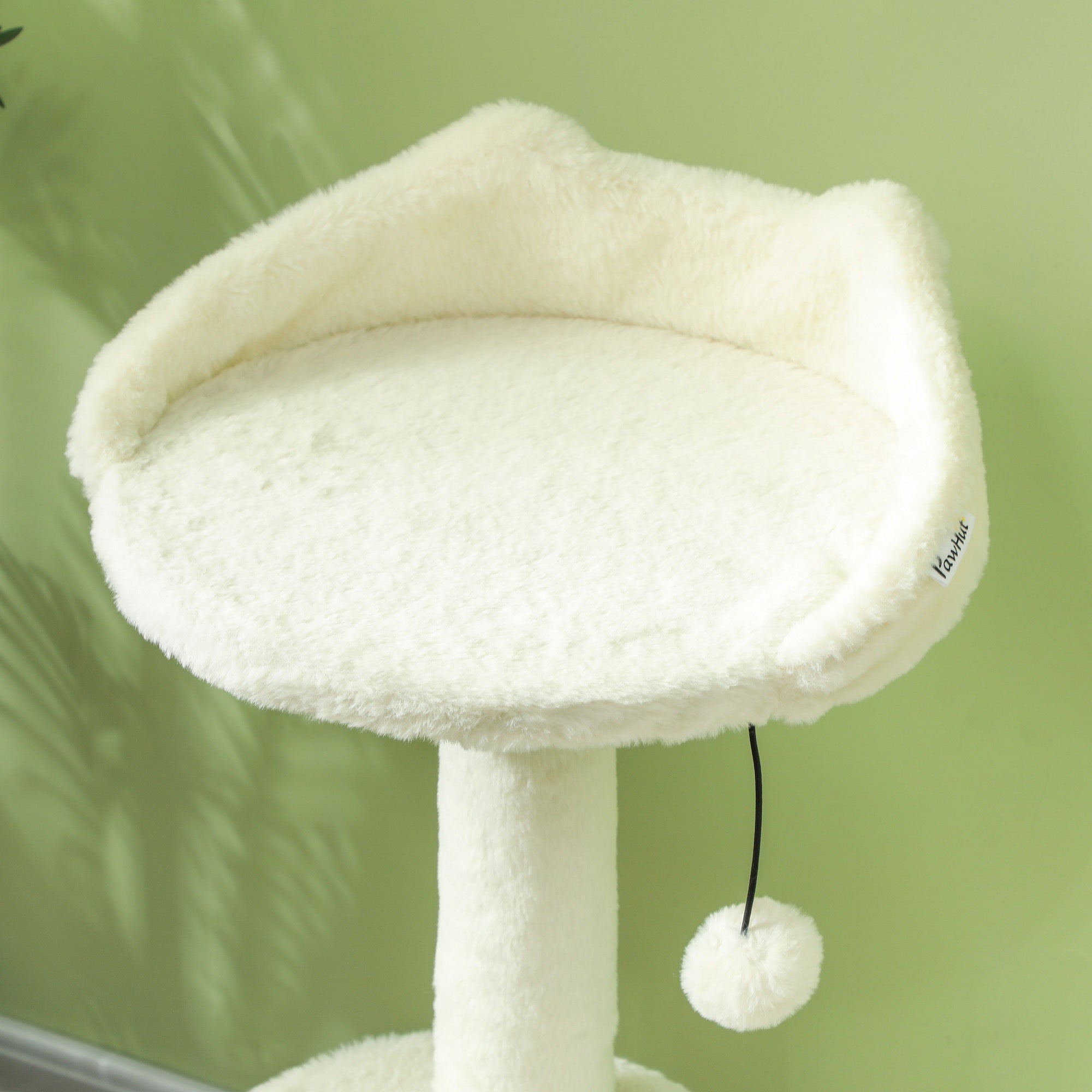 White cat tree with a soft cushion on a green background