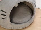 Gray pet bed shaped like a cat's face on a wooden floor
