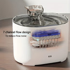 White pet water fountain with clear water flow on a wooden surface