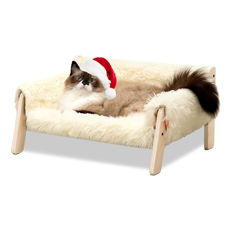 Cat wearing a Santa hat on a fluffy pet bed with wooden legs against a white background