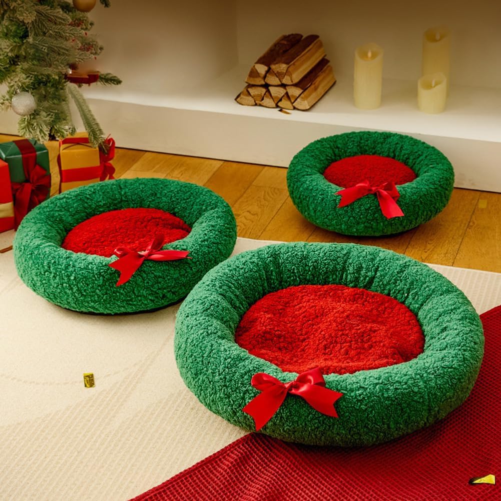 Three green pet beds with red centers and bows on a wooden floor.